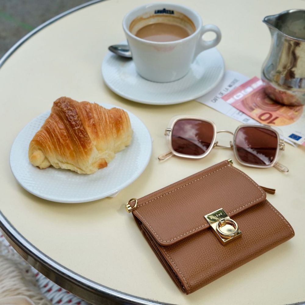 Polene camel leather Wallet on a table at a Paris café with croissant and coffee